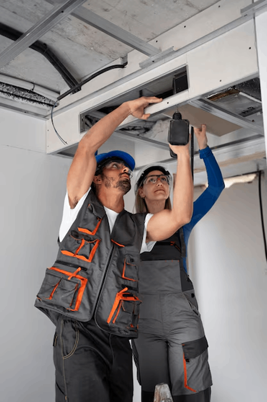 Hombre y mujer trabajando en un conducto de ventilación